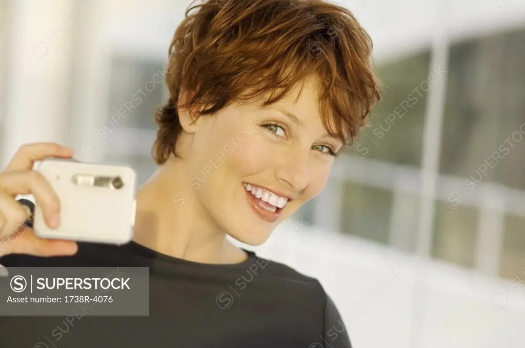 Portrait of a young woman using digital camera
