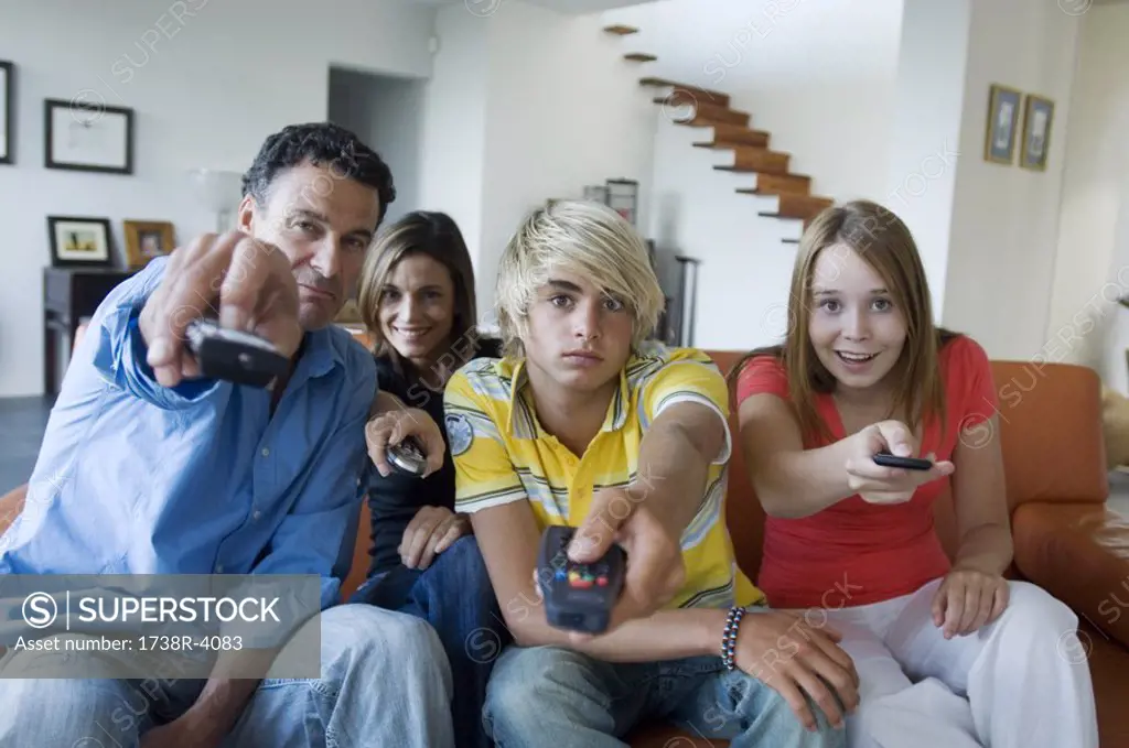Parents and 2 teens using remote-controls