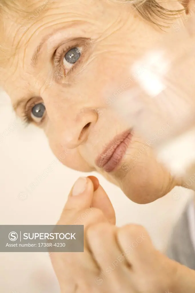 Portrait of senior woman holding pill