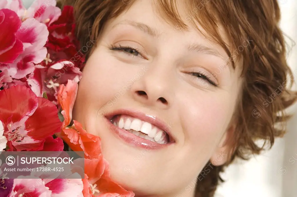 Portrait of smiling woman holding bunch of flowers