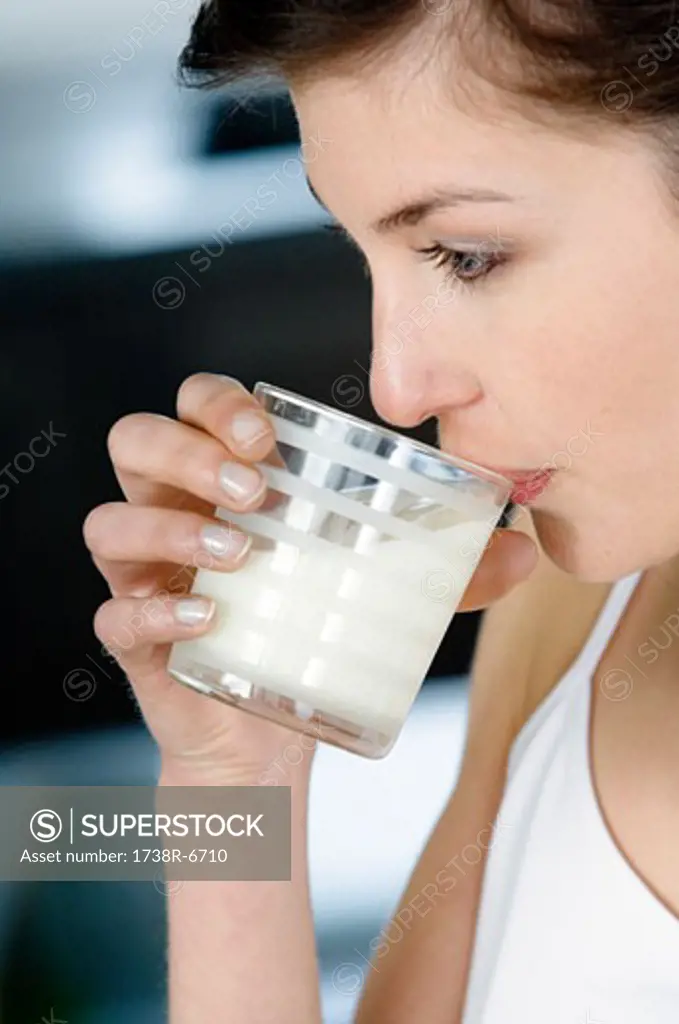 Portrait of a young woman drinking milk
