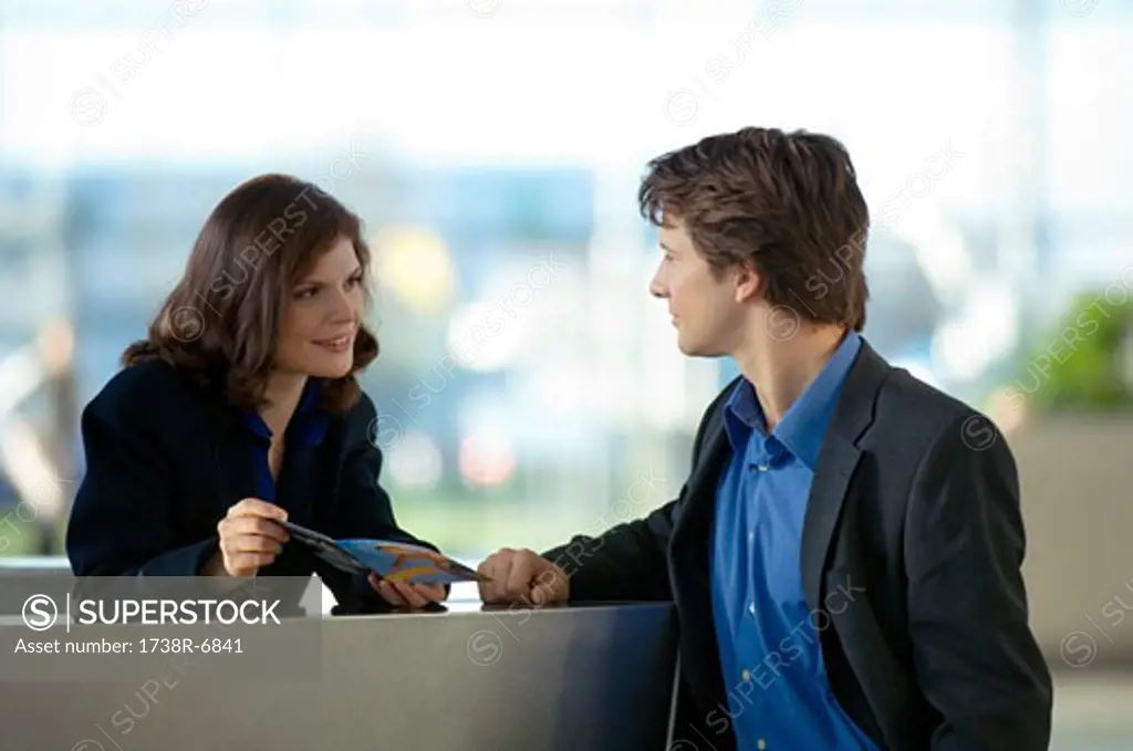 Receptionist showing a brochure to a businessman