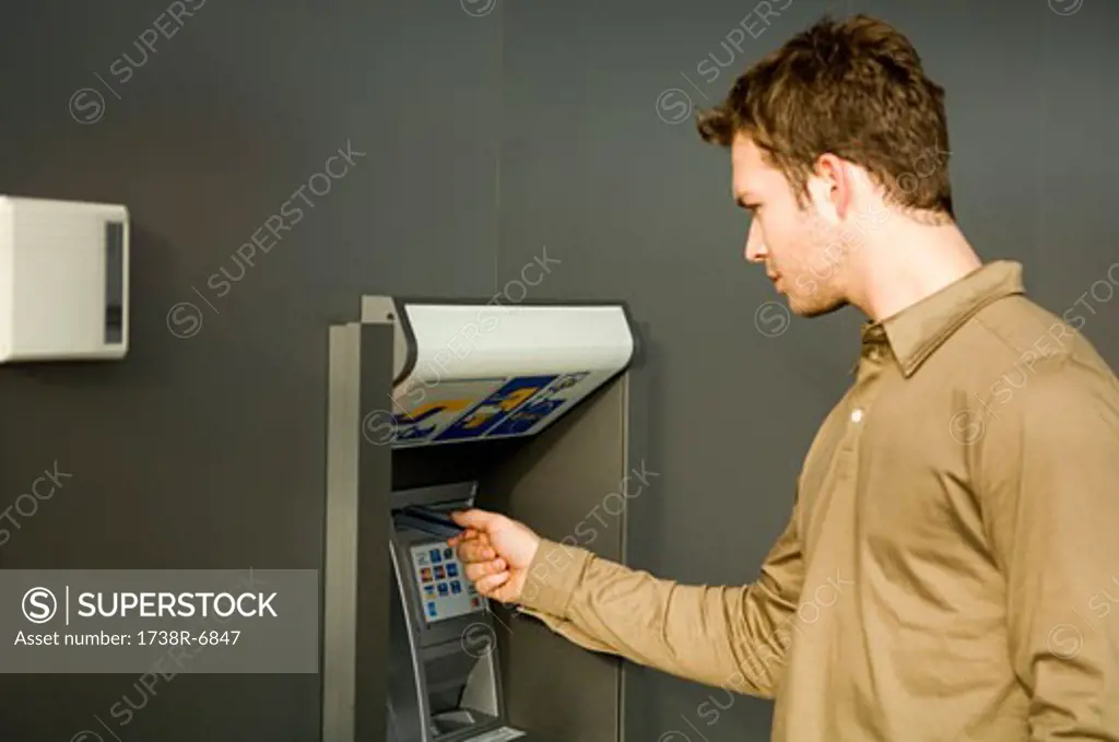 Young man using an ATM