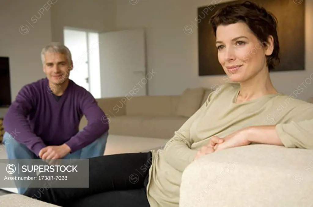 Mid adult woman and a mature man sitting in a living room
