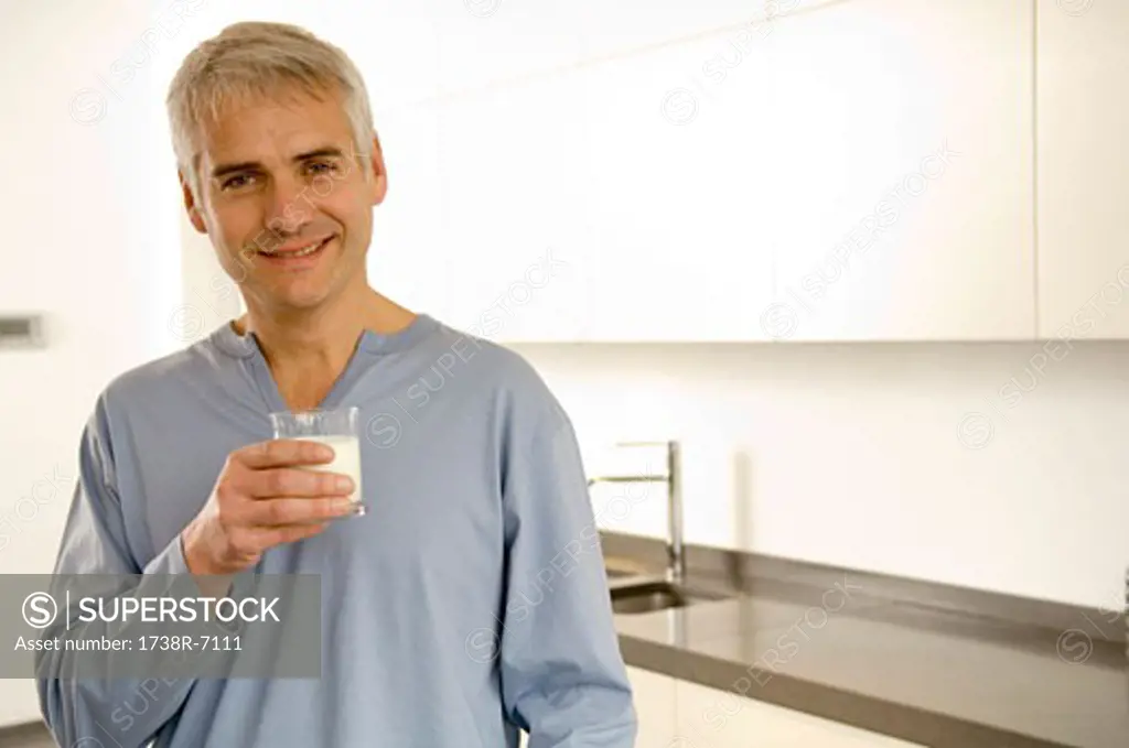 Portrait of a mature man holding a glass of milk