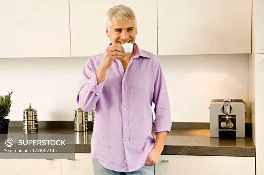 Mature man drinking tea in the kitchen