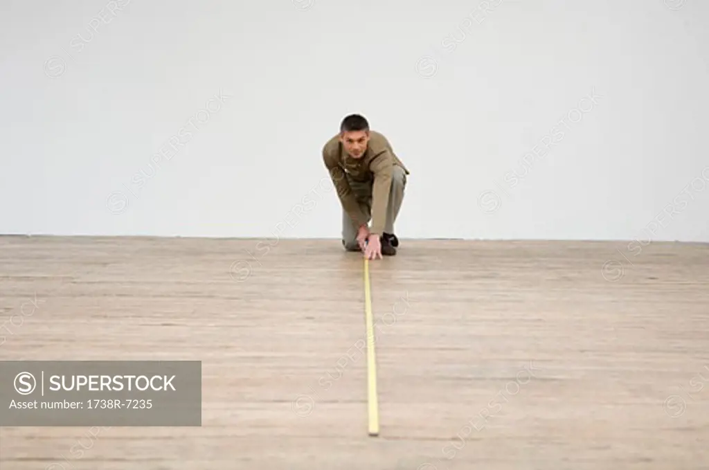Interior designer measuring the hardwood floor with a tape measure