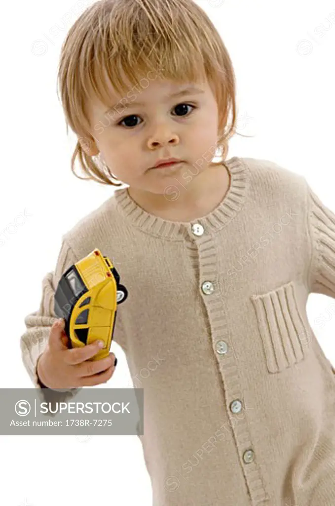 Portrait of a baby boy holding a toy car