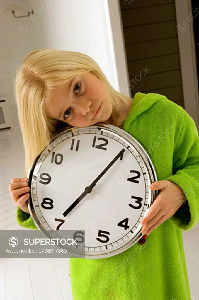Portrait of a girl holding a clock