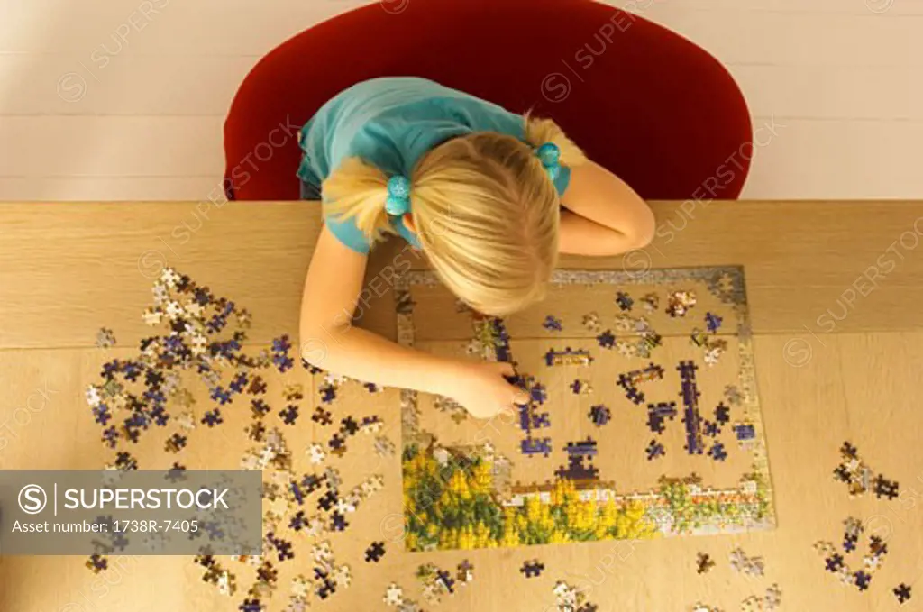 High angle view of a girl playing a jigsaw puzzle