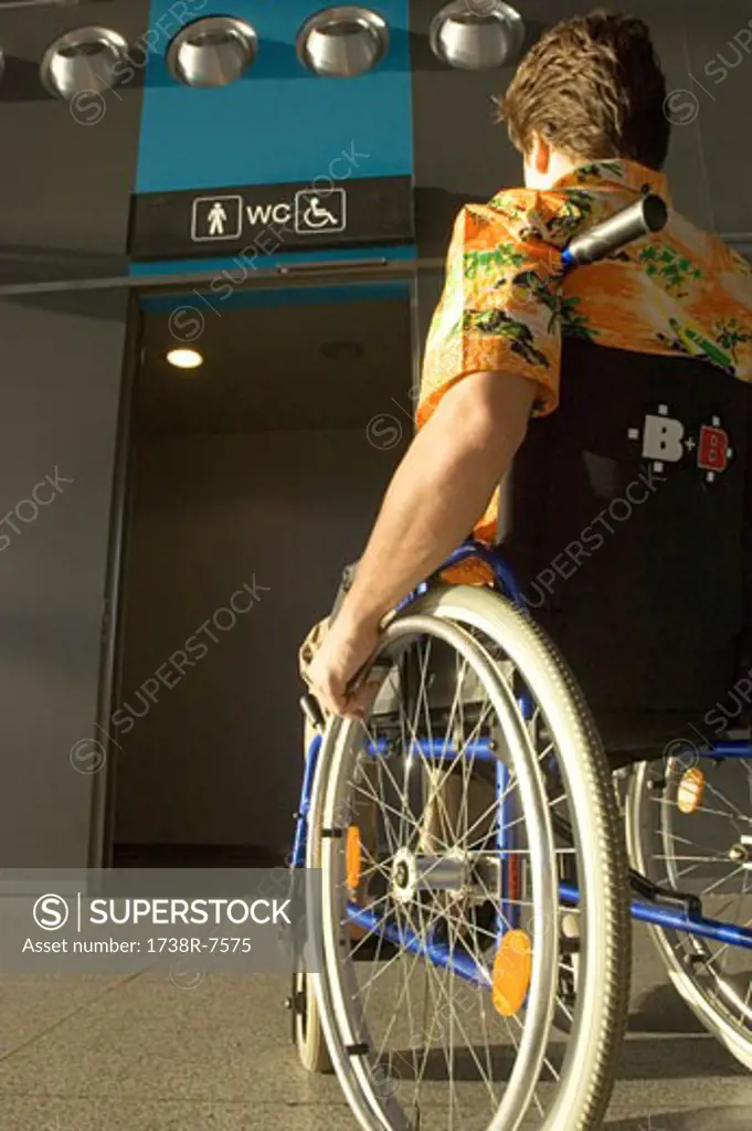 Rear view of a mid adult man sitting in a wheelchair