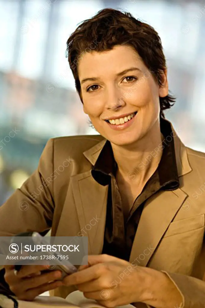 Portrait of a businesswoman operating a mobile phone and smiling