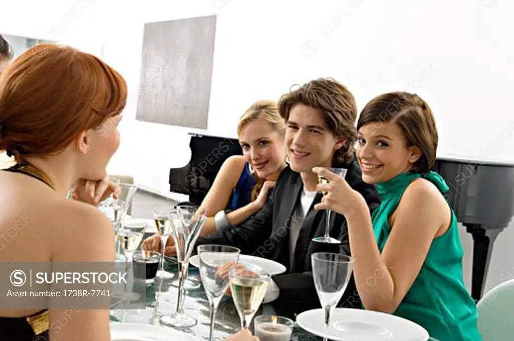 Portrait of a teenage boy with his friends at a dinner party
