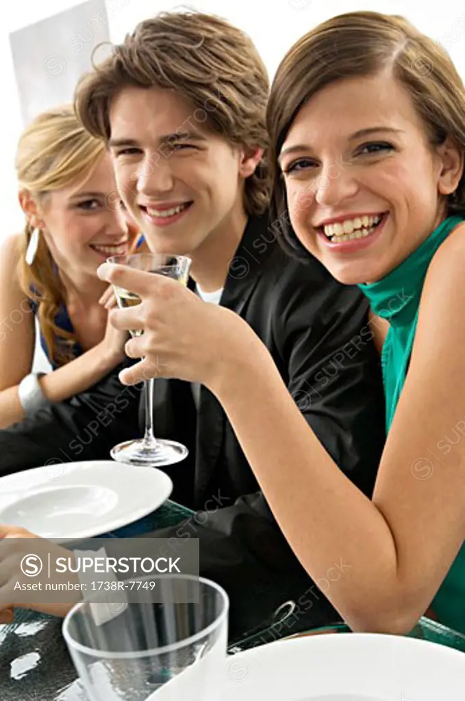 Two young women with a teenage boy at a dinner party