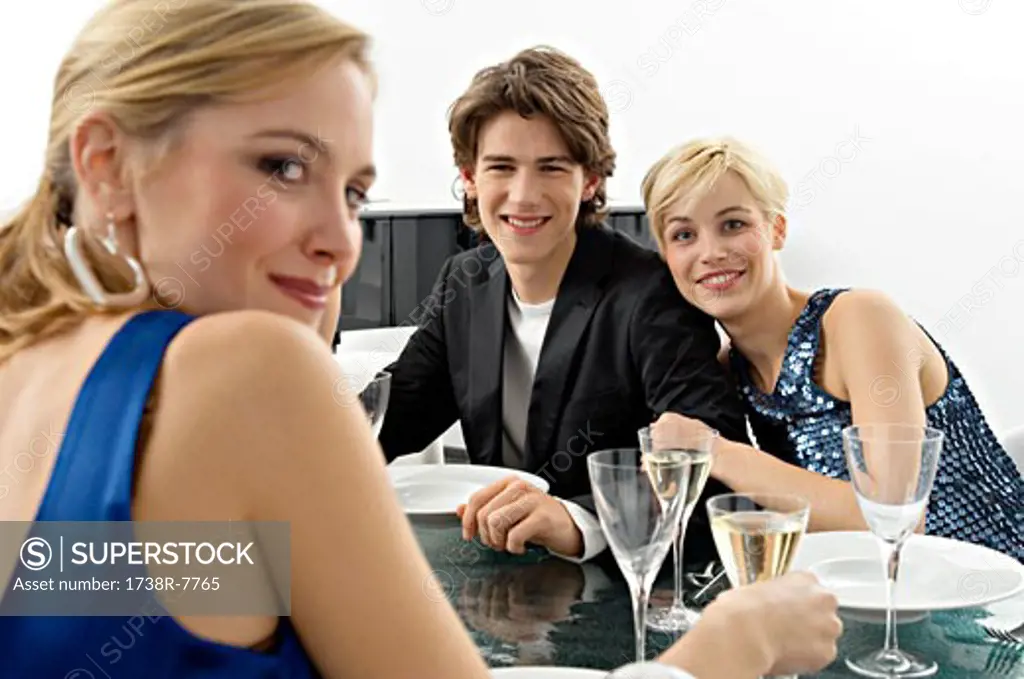 Two young women with a teenage boy at a dinner party