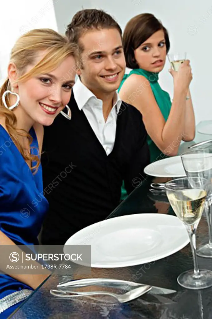 Young man with two young women at a dinner party