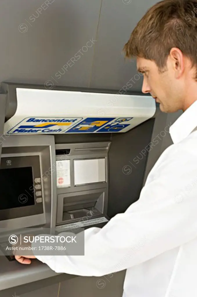 Side profile of a businessman using an ATM