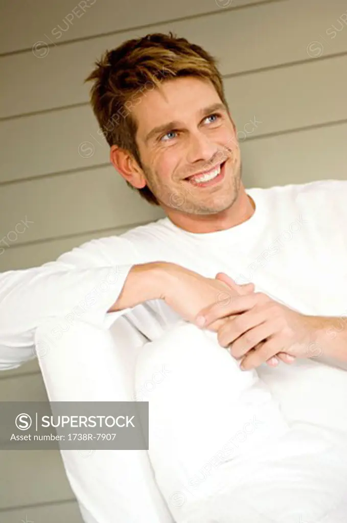 Mid adult man sitting on a couch and smiling