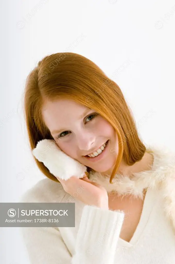 Portrait of a young woman applying face powder
