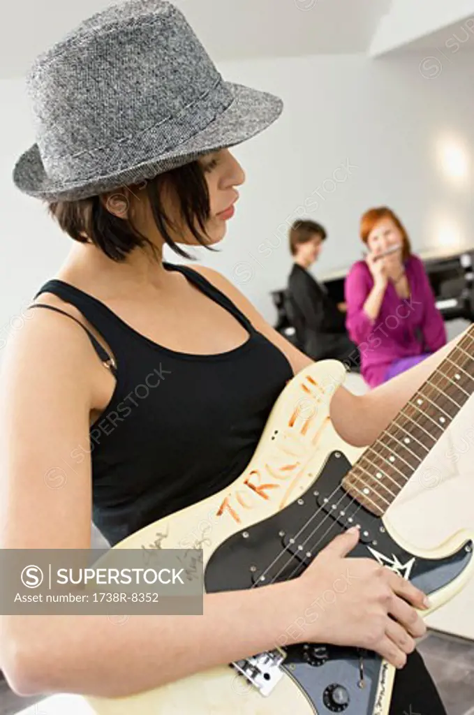 Side profile of a young woman playing a guitar
