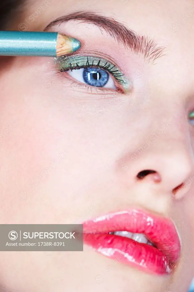Young woman applying eyeliner