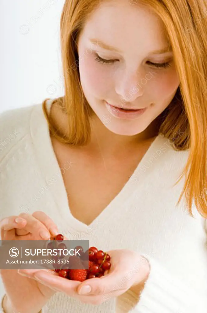 Close-up of a young woman holding berry fruits