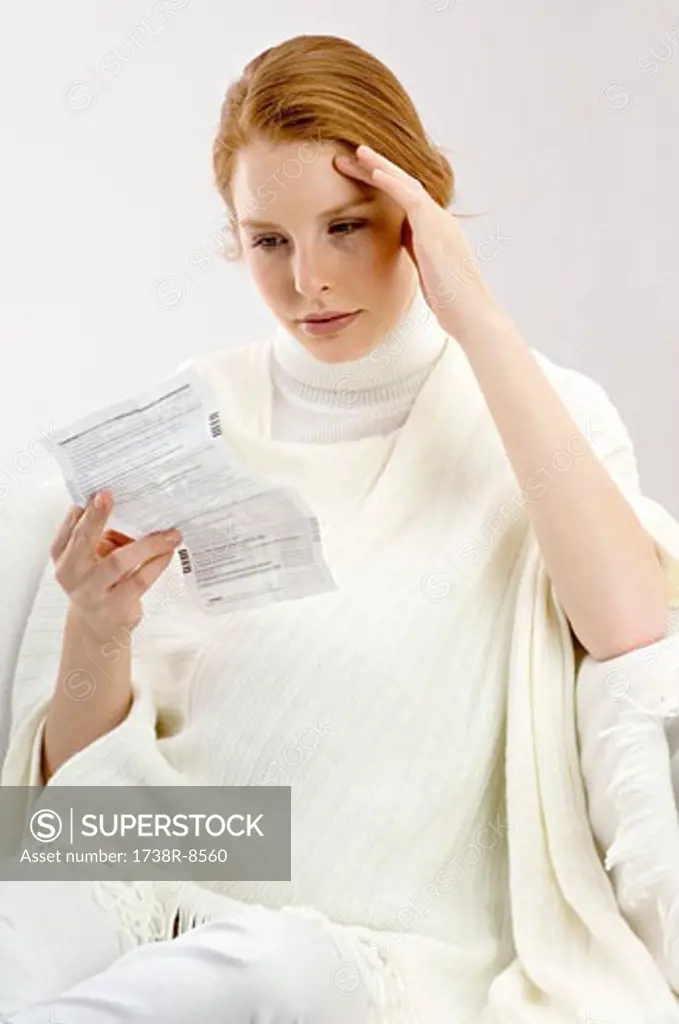 Close-up of a pregnant young woman reading a medical report