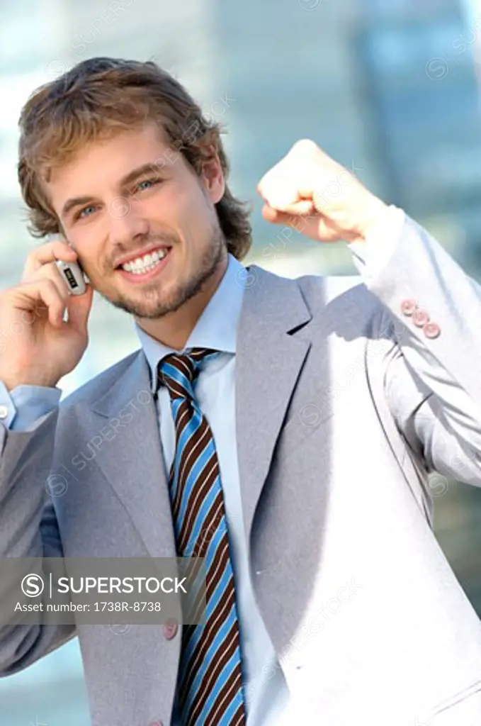 Young businessman using mobile phone, portrait