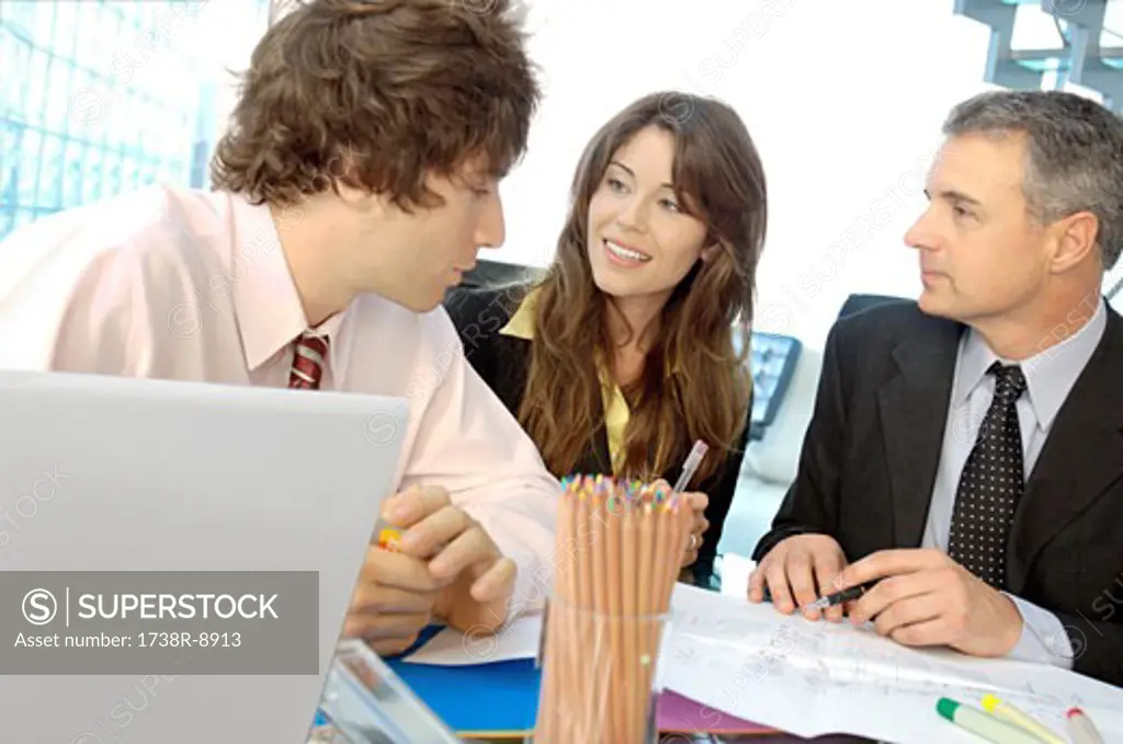 Business people discussing in office, smiling