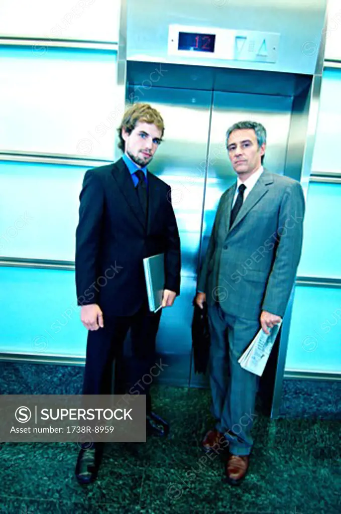 Businessmen waiting for elevator, portrait