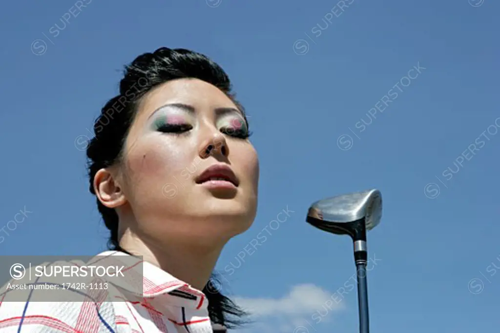Portrait of a young woman with a golf club.