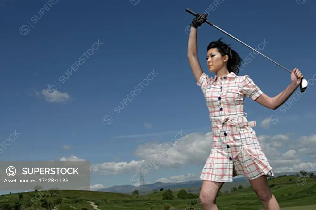 Woman posing with a golf club.