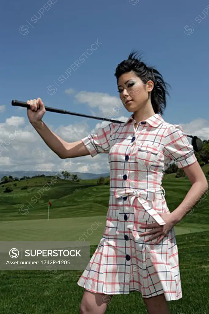 Young woman holding a golf club.