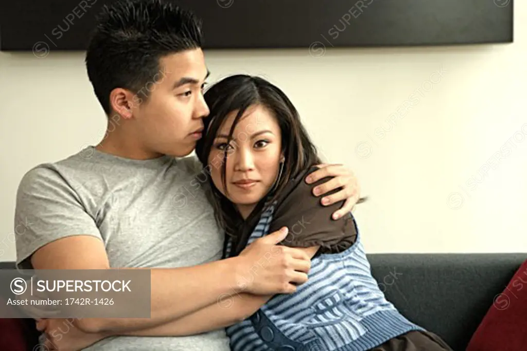 Young couple hugging, portrait