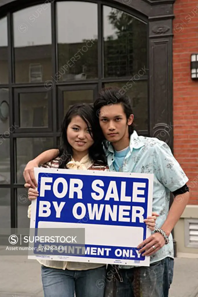 Young couple with advertisement board, portrait