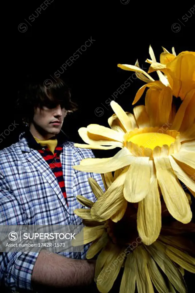 Young man with paper sunflowers