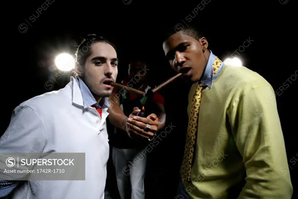 Three young men, two with cigars