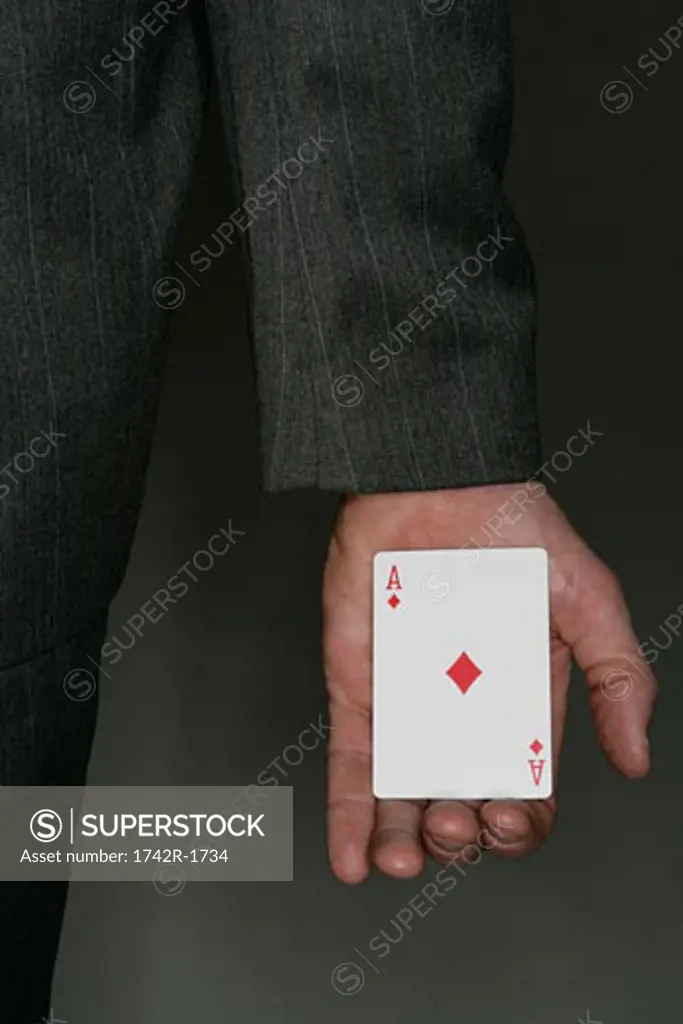 Businessman with playing card in hand, close-up