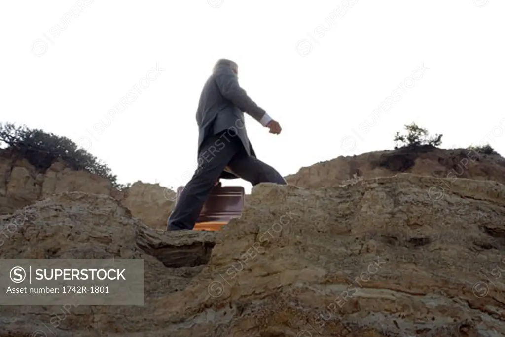 Business man walking on edge of cliff