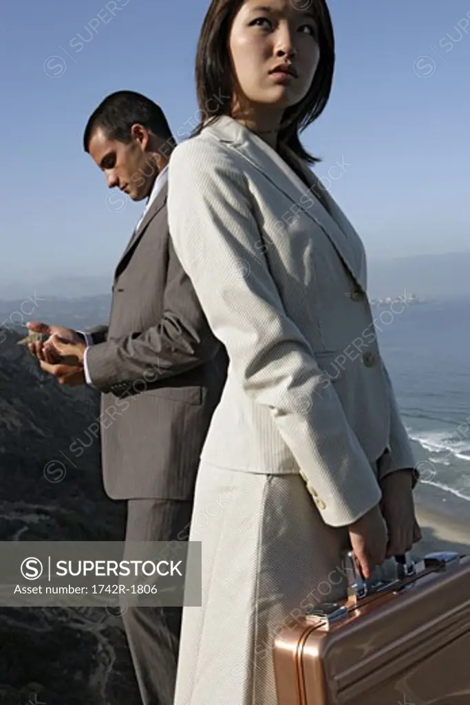 View of a man and a woman standing on a cliff.