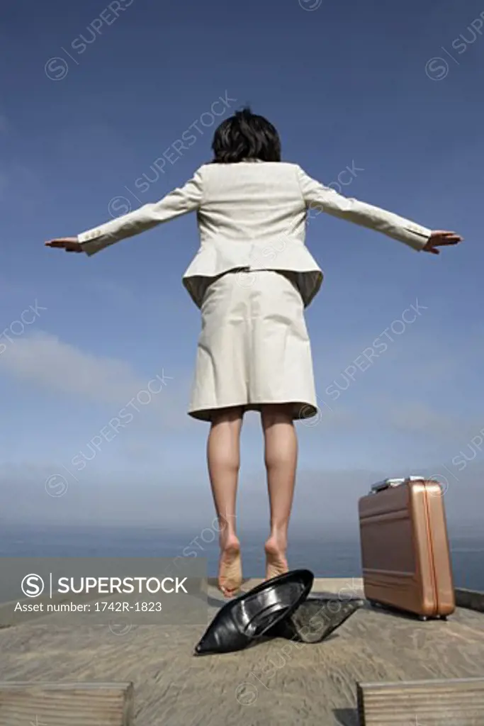 View of a woman jumping on a wooden plank.