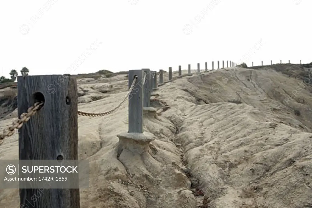 View of a row of posts set on the edge of a cliff.