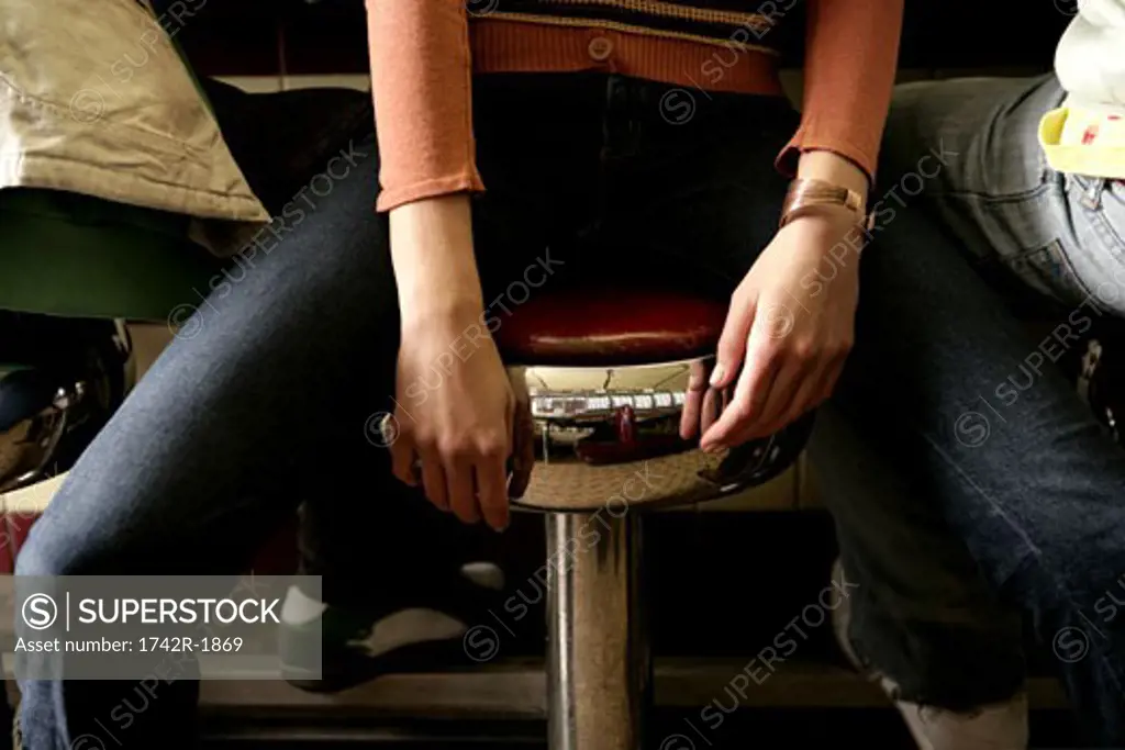 People sitting on stools, midsection
