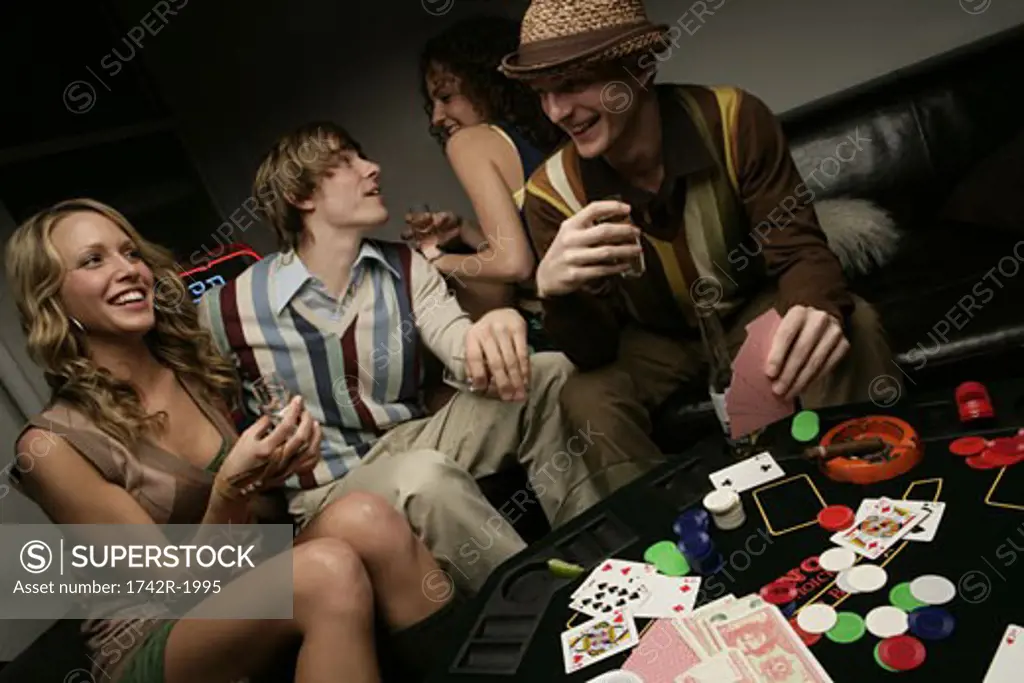 View of couples playing a card game.