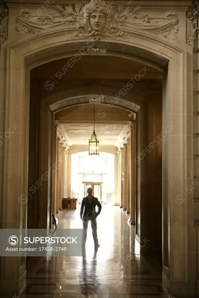 View of a man standing in a hallway.
