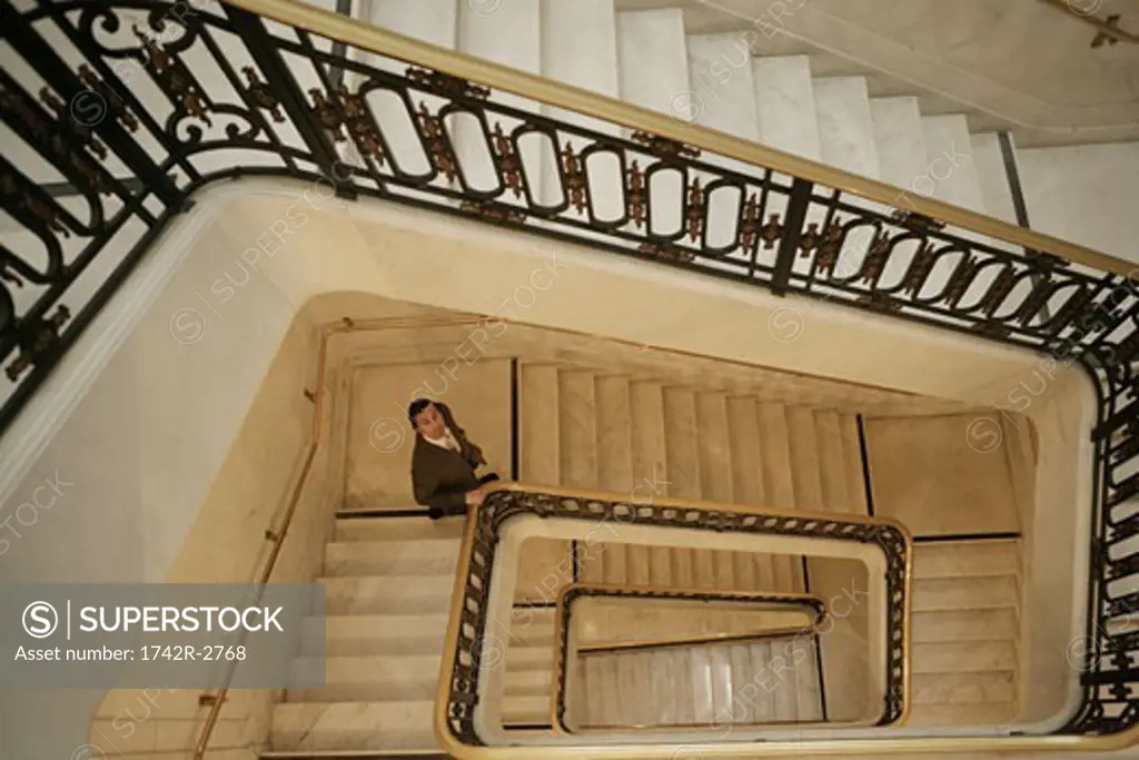 View of a businessman climbing down a stairway.