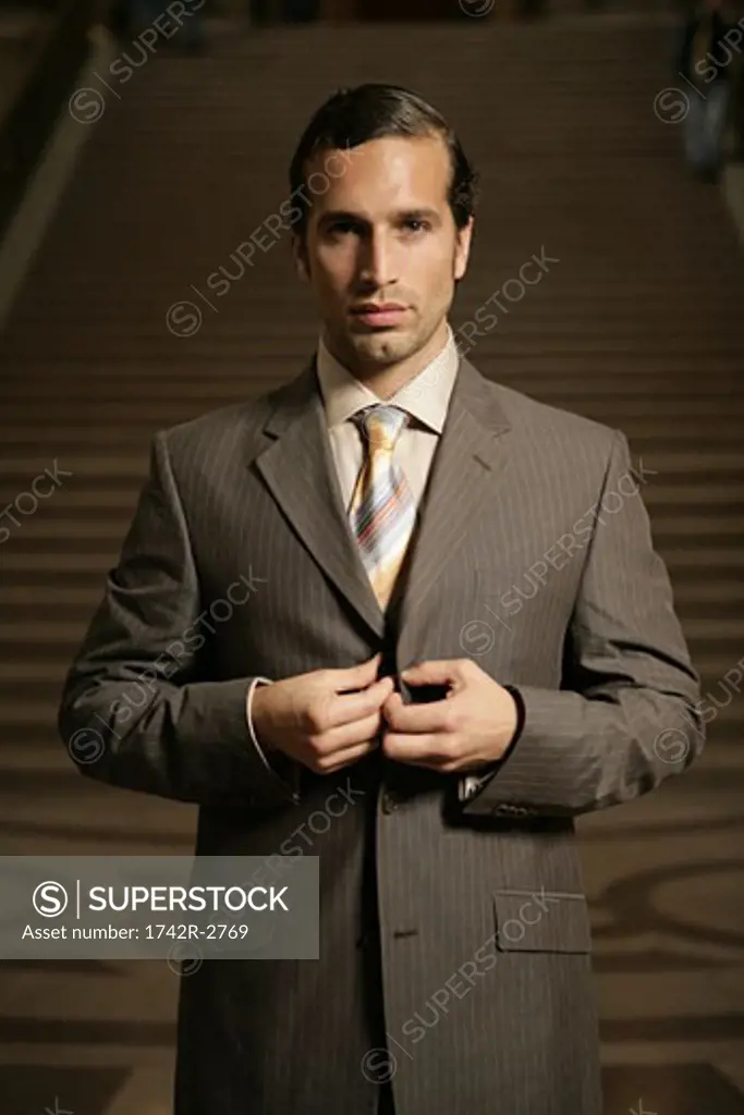 View of a businessman standing in front of a stairway.