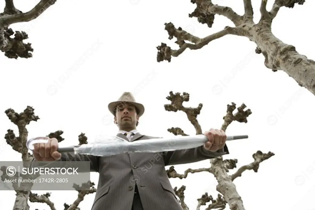 View of a businessman holding an umbrella.
