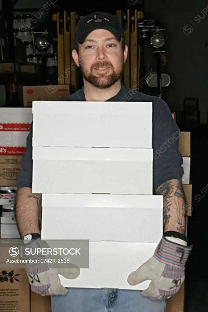 View of a man holding white boxes.