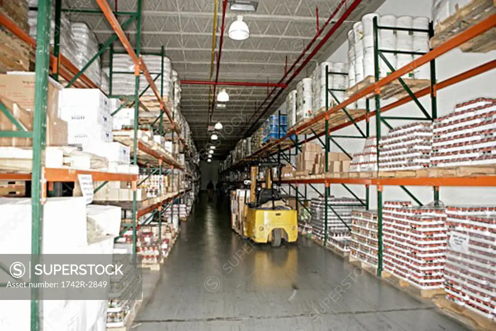 View of a forklift inside a well stocked warehouse.
